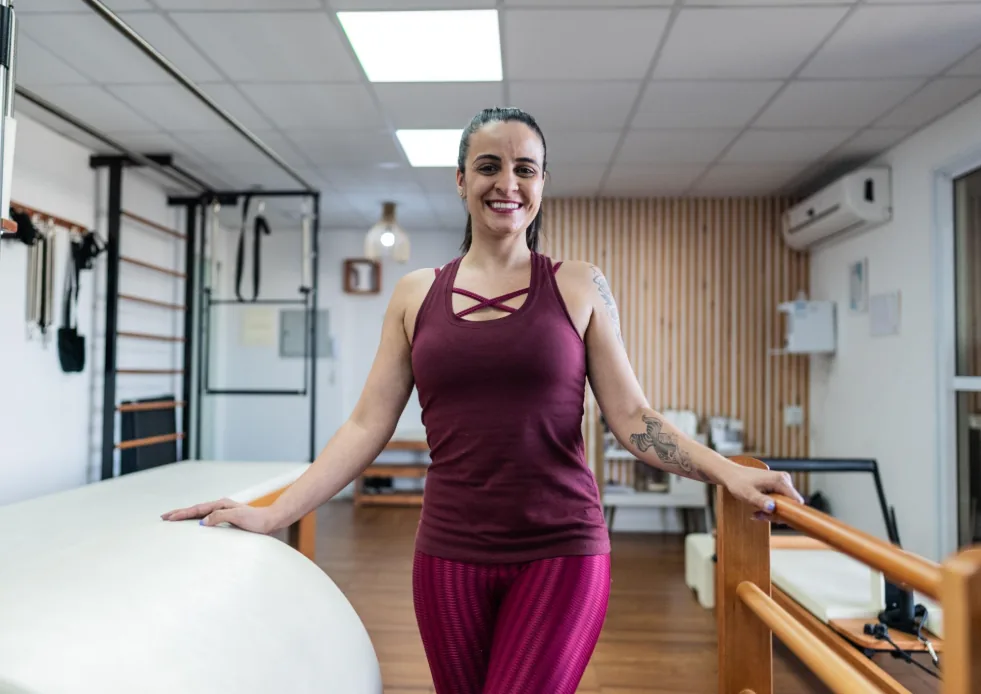 Criadora do Método P30 em um estúdio de pilates, ao lado dos equipamentos